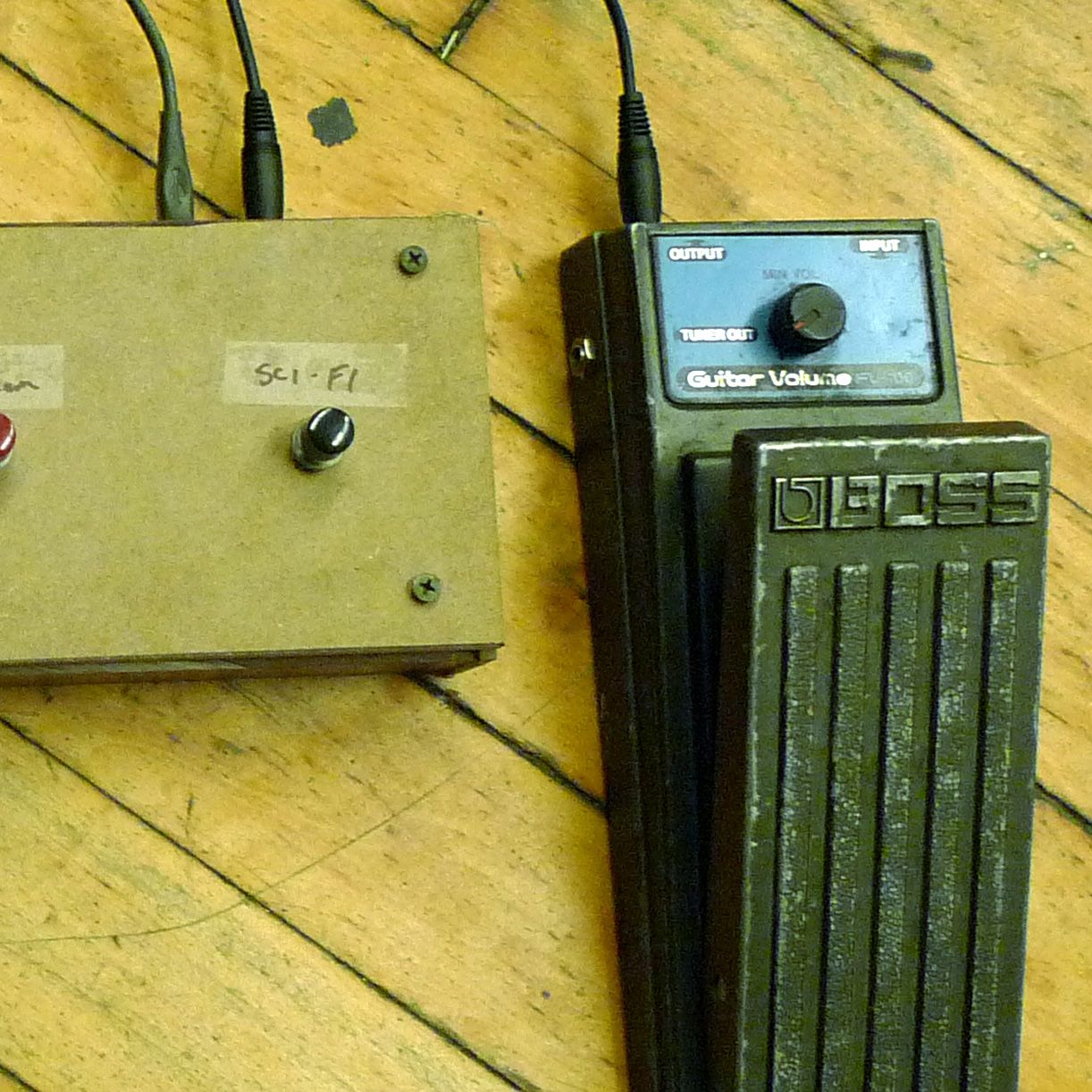 A guitar effects pedal next to a foot switch labeled 'sci-fi'.