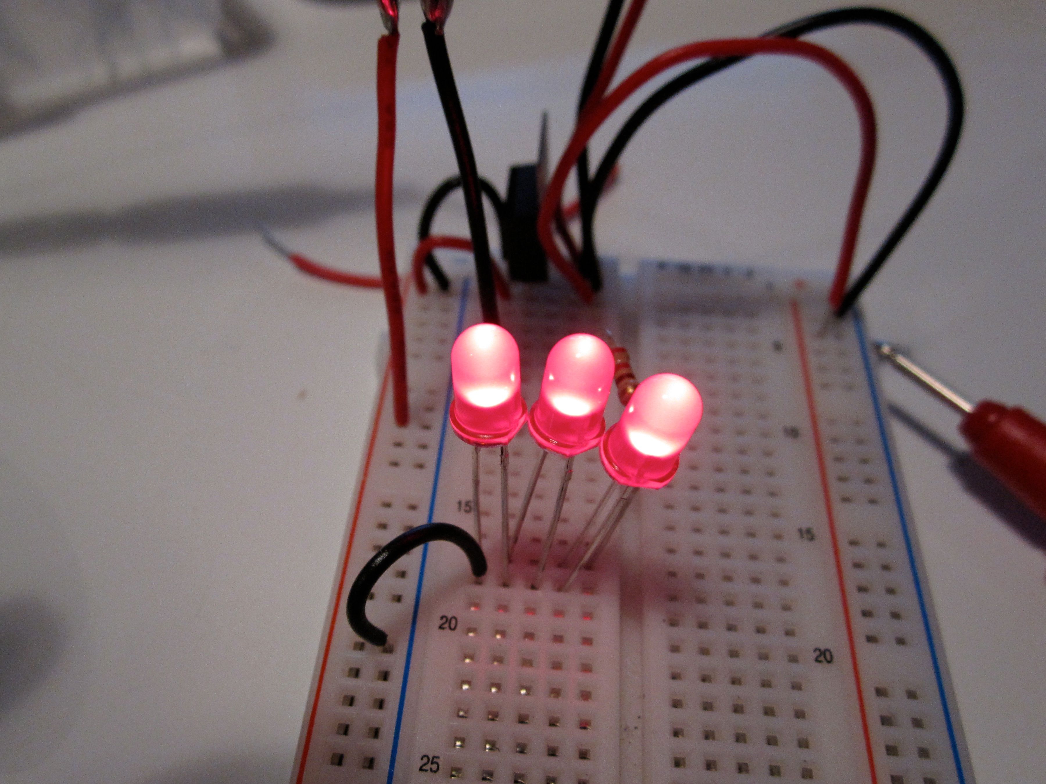 Three illuminated LEDs on a breadboard