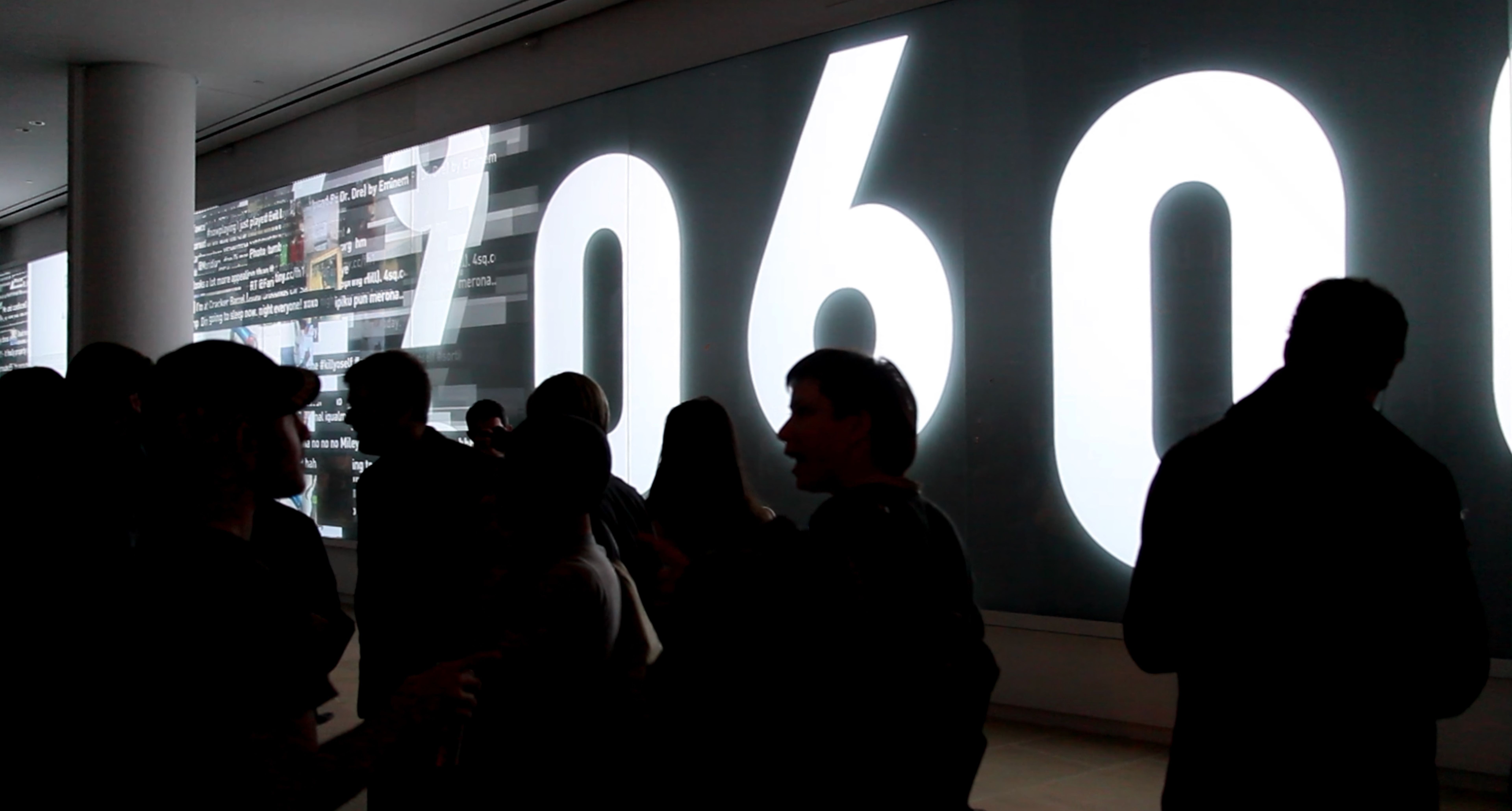 A video wall showing large digits and a stream of tweet text