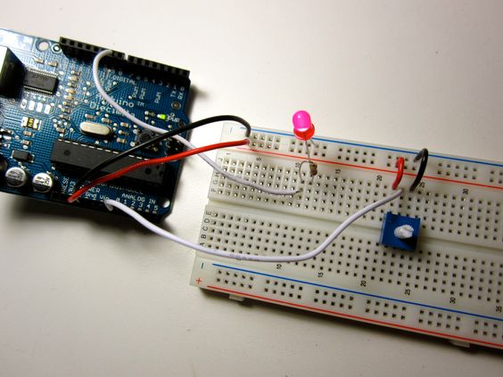 An Arduino connected to a breadboard with an LED and a potentiometer