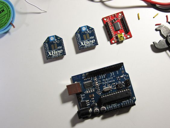 Two XBee radios and an XBee to USB adapter next to an Arduino