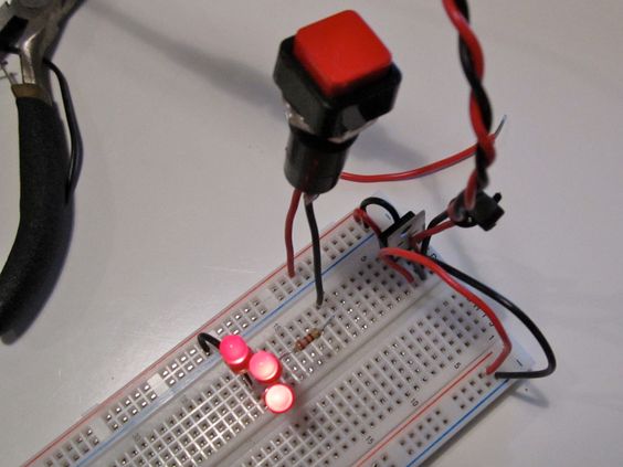 A switch and three LEDs attached to a breadboard