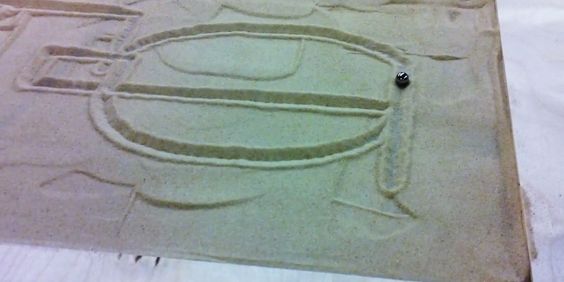 A marble tracing a path through sand